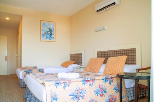 a hotel room with two beds and a table at Belkon Hotel in Belek