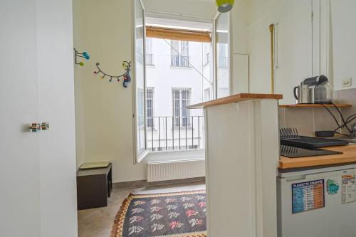 une cuisine avec un comptoir et une fenêtre dans l'établissement Charming Studio - Saint Apoline, à Paris