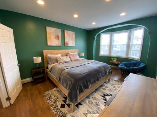 a bedroom with green walls and a bed and a table at Rainforest Retreat 20m to NYC FREE Parking - Sleeps 16 in Bayonne