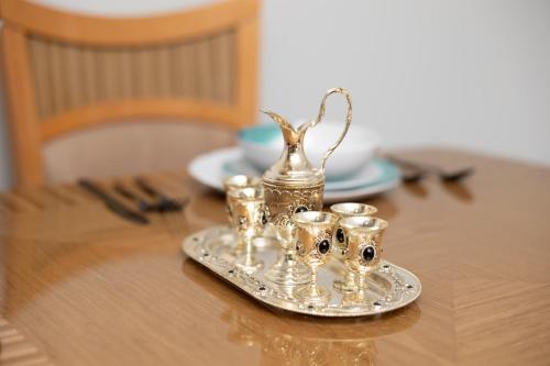 a silver tea set on a plate on a table at Sapphire Suite Near NYC in Bayonne