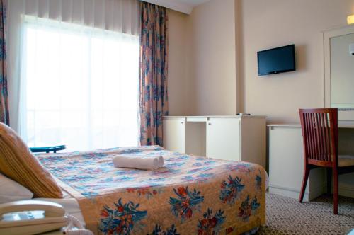 a hotel room with a bed and a television at Belkon Hotel in Belek