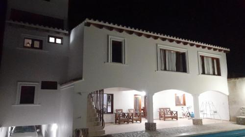 a white house with a pool in front of it at Hospedaje Lupé in Cachí