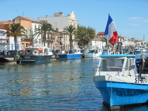un grupo de barcos están atracados en un puerto en LE FLORIDE B Folco de baronchelli, en Le Grau-du-Roi