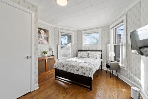 a white bedroom with a bed and a window at Whimsical Two in Bayonne