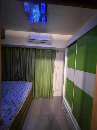 um pequeno quarto com uma cama e uma janela em Shell Residence em Manila