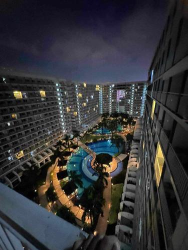 uma vista para uma piscina a partir de um edifício à noite em Shell Residence em Manila