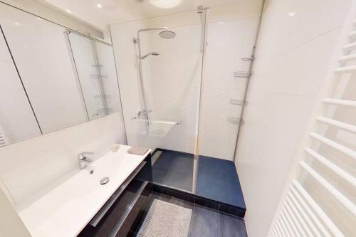 a white bathroom with a shower and a sink at Appartement Nice avec balcon et parking privé in Nice