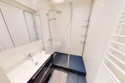 une salle de bain blanche avec une douche et un lavabo dans l'établissement Appartement Nice avec balcon et parking privé, à Nice