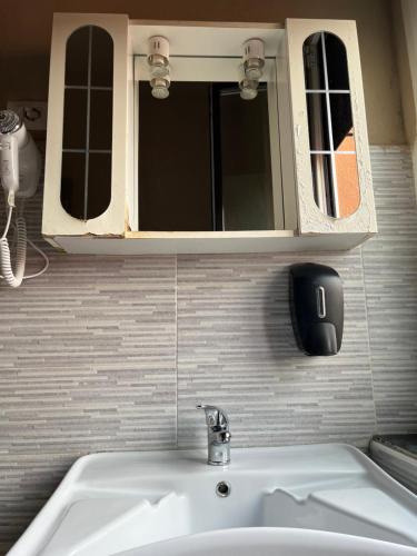 a bathroom with a sink and a mirror above it at Gloria Hostel Milano in Milan