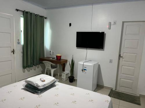 a bedroom with a bed and a television on the wall at Pousada Amazônia in Rio Branco