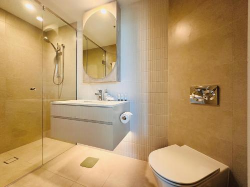 ein Badezimmer mit einem WC, einem Waschbecken und einem Spiegel in der Unterkunft Eyes on the Fireworks Lux Riverfront 2KingBed Apt in Brisbane