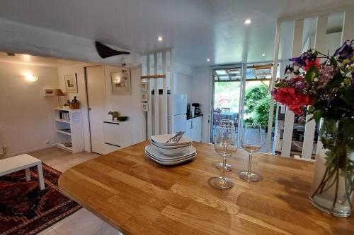 une table à manger avec des verres et un vase de fleurs dans l'établissement Les chaumières de Kerréo, ELISA, à Pluvigner