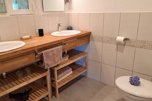 a bathroom with two sinks and a toilet at Chaumière de Kerréo, ELISA in Pluvigner