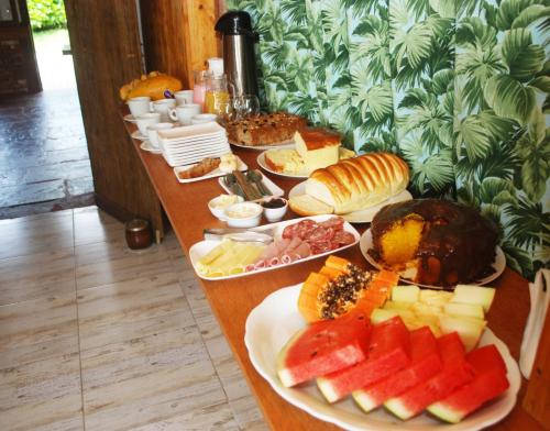 een lange tafel met veel borden eten erop bij Refugio Jardim Mariana in Canela