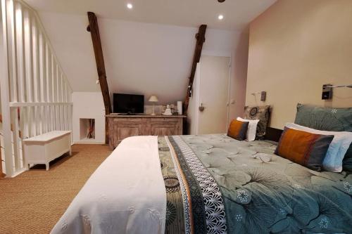 a bedroom with a large bed and a tv at Chaumière de Kerréo, ELISA in Pluvigner