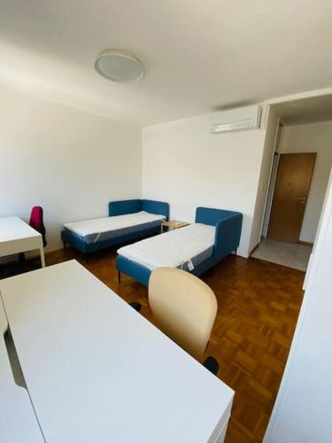 Cette chambre comprend deux lits, une table et des chaises. dans l'établissement Apartment P47, à Koper