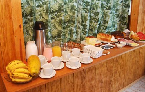 een tafel met een heleboel ontbijtproducten en drankjes bij Refugio Jardim Mariana in Canela