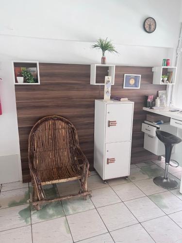 a room with a chair and a white refrigerator at Pousada Amazônia in Rio Branco