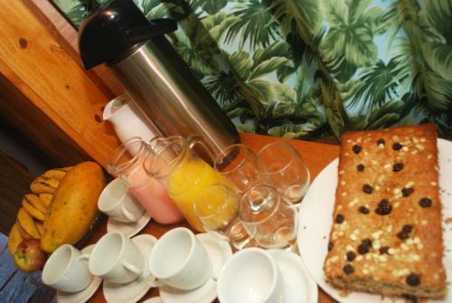 een bord met eten, glazen sinaasappelsap en brood bij Refugio Jardim Mariana in Canela