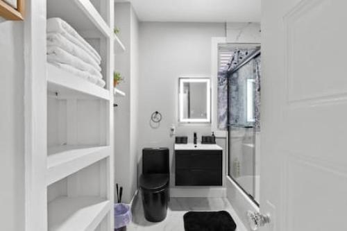 a white bathroom with a shower and a sink at Modern Dream Loft in Bayonne