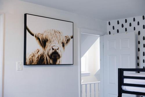 a picture of a cow hanging on a wall at Rainforest Retreat 20m to NYC Parking Sleeps 25 in Bayonne