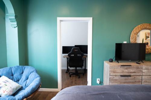 a bedroom with a bed and a chair and a mirror at Rainforest Retreat 20m to NYC Parking Sleeps 25 in Bayonne