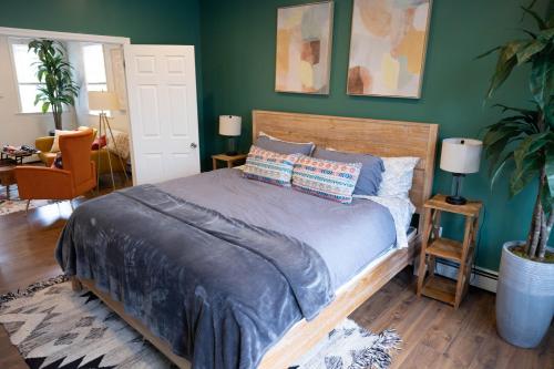a bedroom with a bed and a green wall at Rainforest Retreat 20m to NYC Parking Sleeps 25 in Bayonne