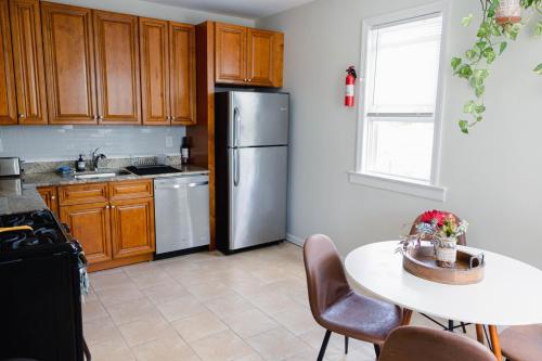 a kitchen with a refrigerator and a table with chairs at Rainforest Retreat 20m to NYC Parking Sleeps 25 in Bayonne