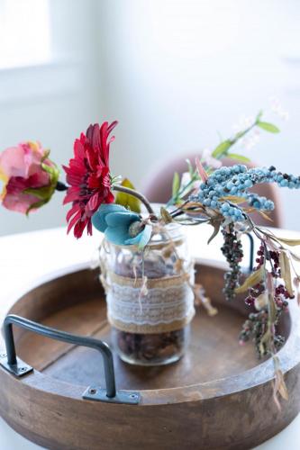 a vase filled with flowers on a wooden table at Rainforest Retreat 20m to NYC Parking Sleeps 25 in Bayonne