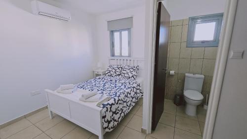 a small bedroom with a bed and a toilet at STAY Skyline Nest in Larnaka