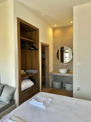 a bathroom with a bed and a sink and a mirror at Serenity Suites in Halki
