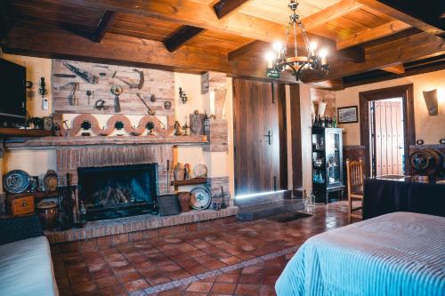 a living room with a fireplace and a bed at La Casita de los Cactus in Armilla