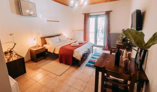 Schlafzimmer mit einem Bett, einem Tisch und einem TV in der Unterkunft Mountain Hotels "Aroanides" in Planitéron