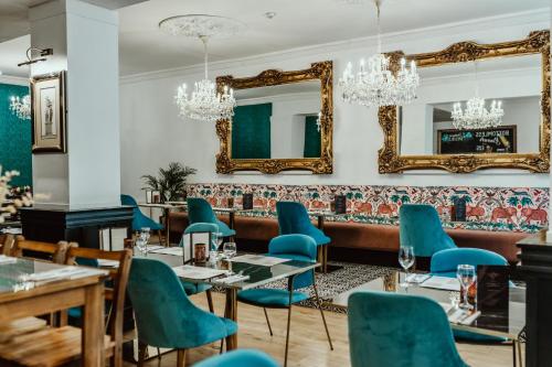 a restaurant with blue chairs and a mirror at The Kings Arms Hotel in Berwick-Upon-Tweed