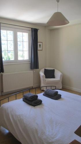 a bedroom with a bed with two towels on it at La Maison Rose in Saillans