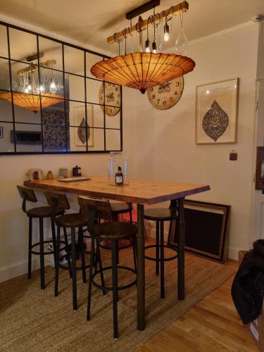 une salle à manger avec une table et quelques lustres dans l'établissement OFFRE SPECIALE JO AVEC TRANSPORT GRATUIT SUR DEMANDE Chambre privée dans grande maison de ville avec jardin, à Wattrelos