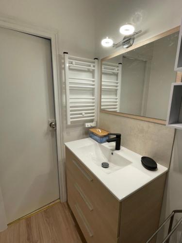 a bathroom with a sink and a mirror at Appartement hyper centre, Parking gratuit in Fontainebleau