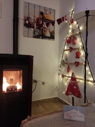 a christmas tree with lights next to a fireplace at B&B A casa di Carla in Castelsaraceno