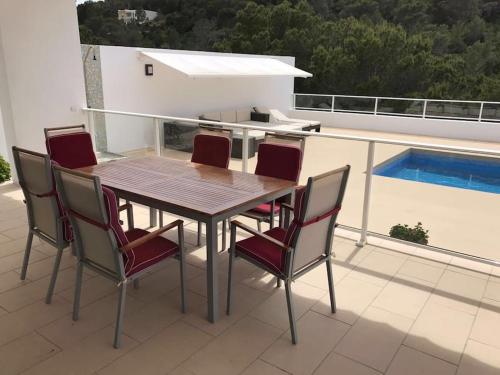 a table and chairs on a balcony with a pool at Chalet en C.Vadella - Piscina privada in Cala Vadella