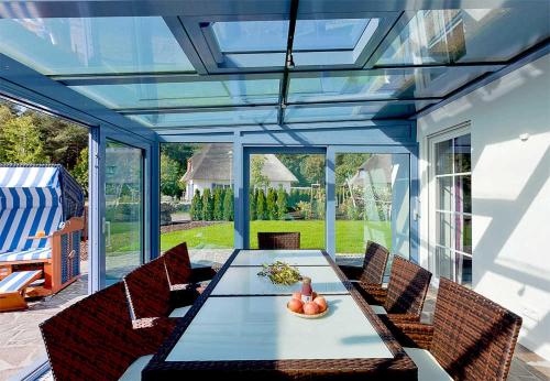 a conservatory with a table and chairs on a patio at Ferienhaus 170 in Peenemünde