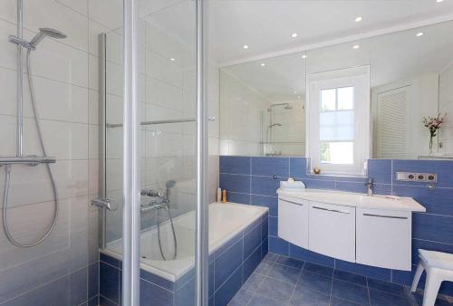 a bathroom with a shower and a tub and a sink at Ferienhaus 170 in Peenemünde