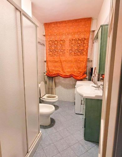 cortina naranja en el baño con aseo y lavabo en Casa Natale, en Pralungo
