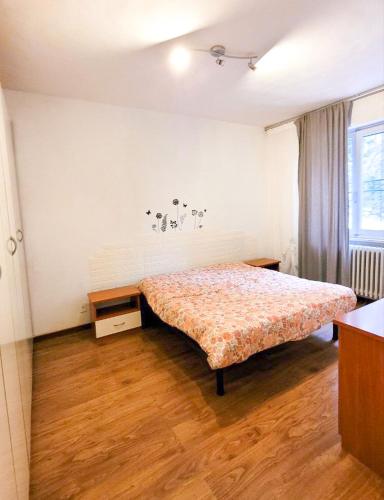 1 dormitorio con 1 cama y suelo de madera en Casa Natale, en Pralungo