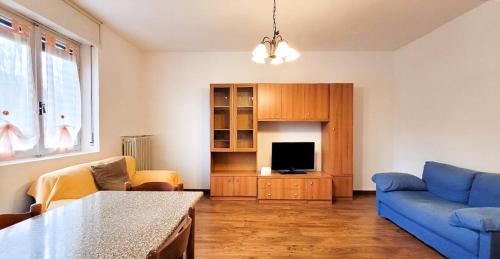 sala de estar con sofá azul y TV en Casa Natale, en Pralungo