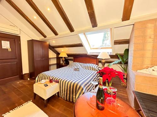 a bedroom with a bed and a table with a bottle of wine at Villa Anica Dubrovnik - luxurious with a sea view in Dubrovnik