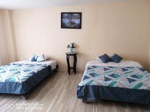 2 nebeneinander sitzende Betten in einem Schlafzimmer in der Unterkunft LindaHouse in Baños
