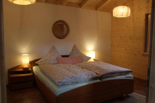 a bedroom with a bed with two lamps and a mirror at Chalet Charmant-Santelmann in Bischoffingen
