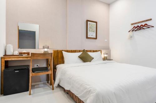 a bedroom with a bed and a desk with a mirror at Sunset Mu Style Inn in Xiaoliuqiu