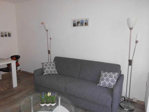 uma sala de estar com um sofá e uma mesa em Wohnung 59 em Ostseebad Karlshagen