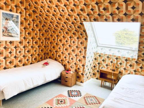 een slaapkamer met een houten muur, een bed en een raam bij Piriac, maison familiale, accès direct plage, 12 couchages in Piriac-sur-Mer